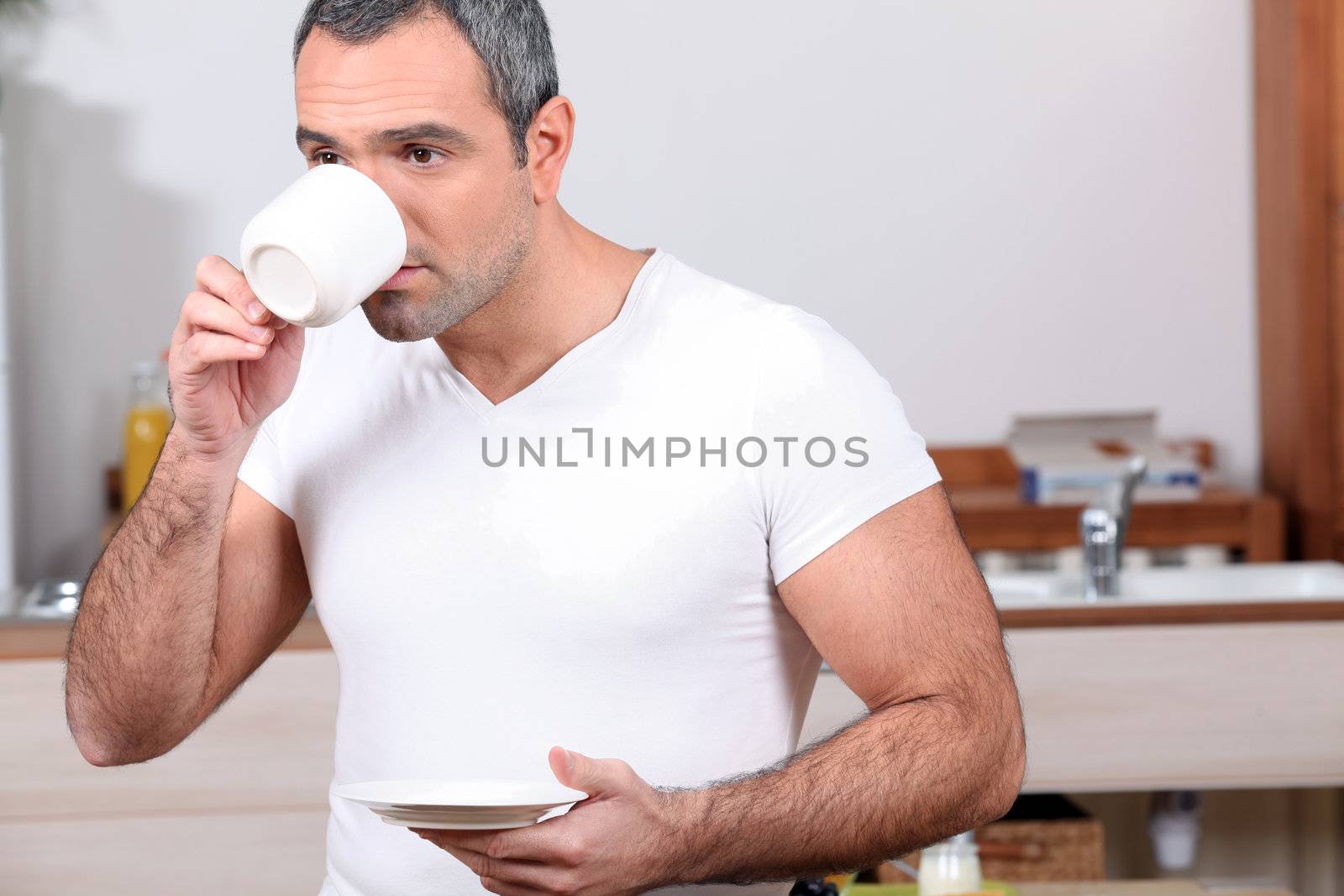 Man drinking coffee in kitchen