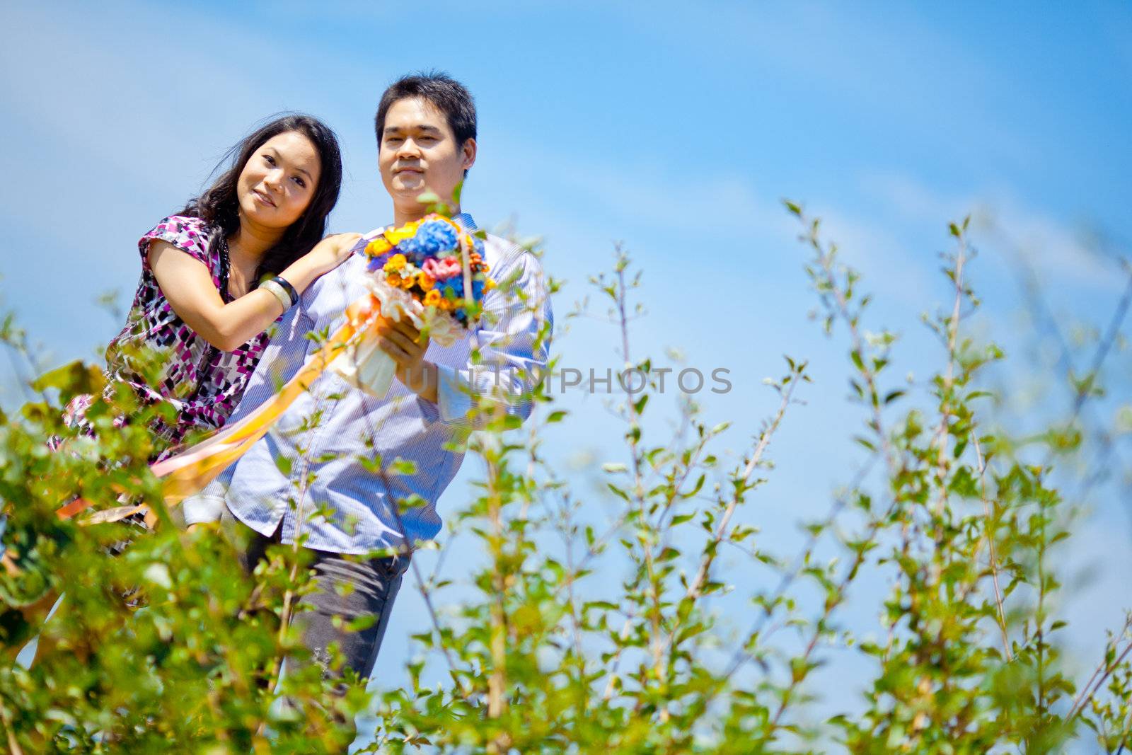 romantic couples standing outdoors with flowers bouquet