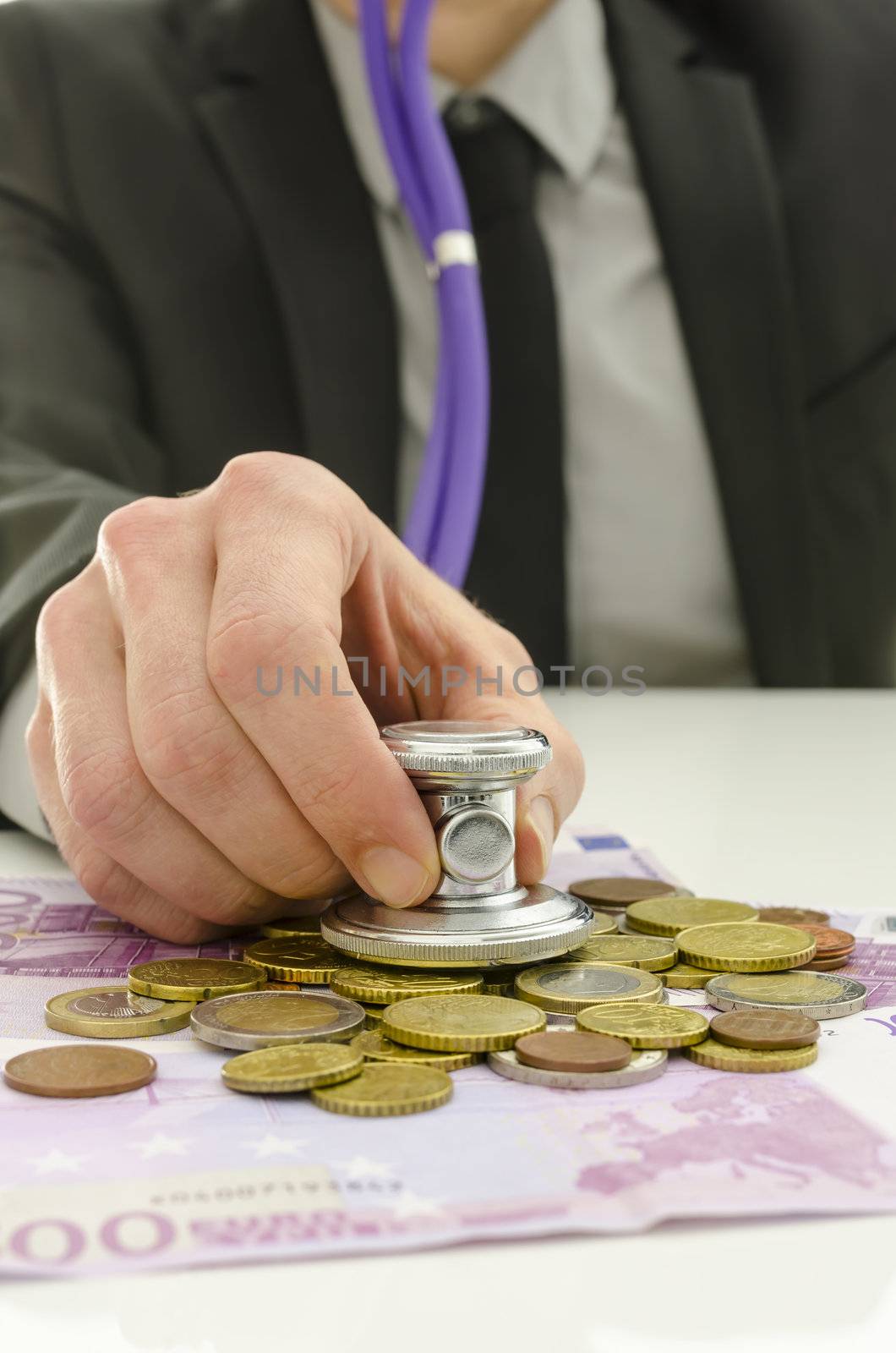 Closeup of financial advisor checking European union currency with stethoscope.