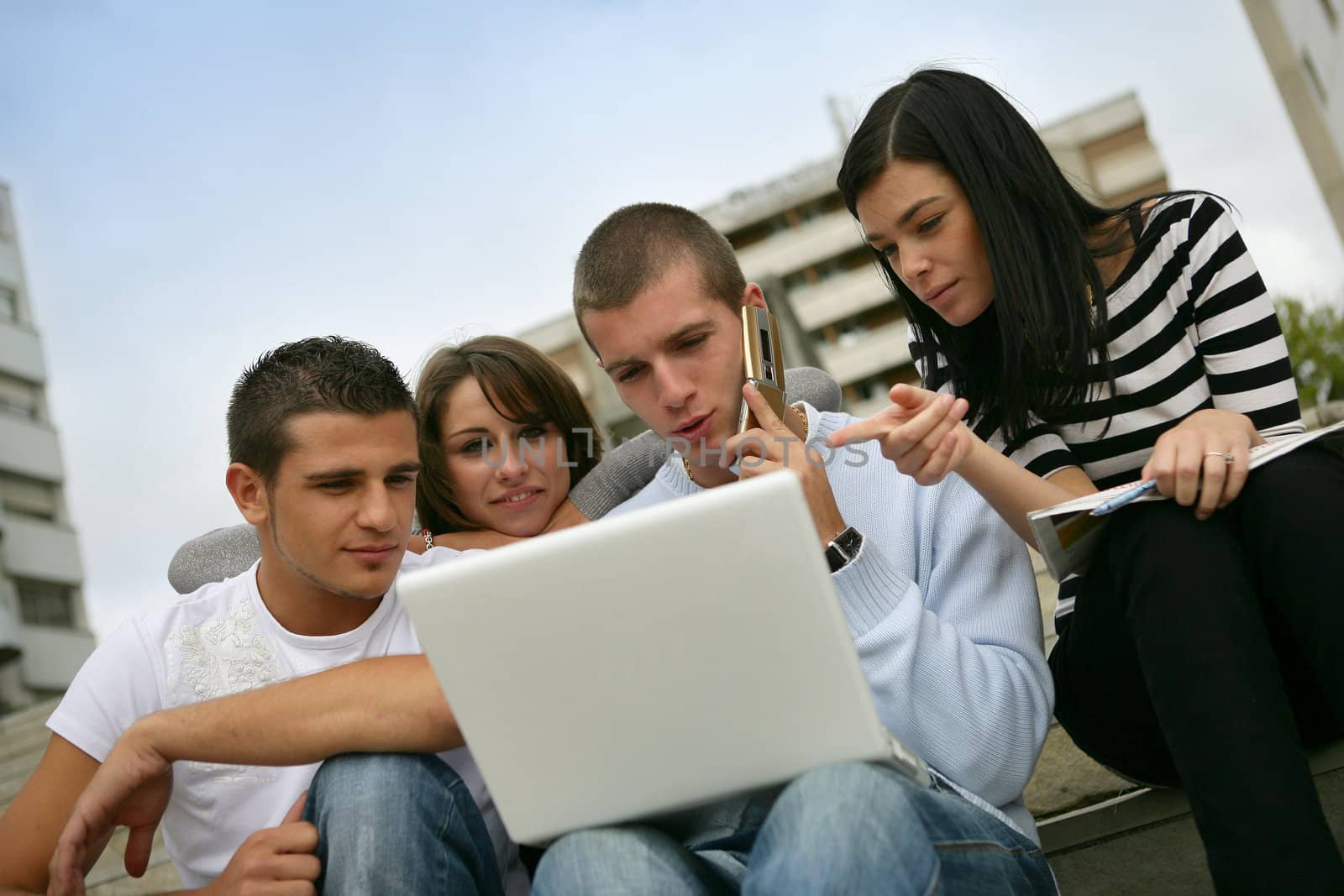 Four teenagers using laptop computer