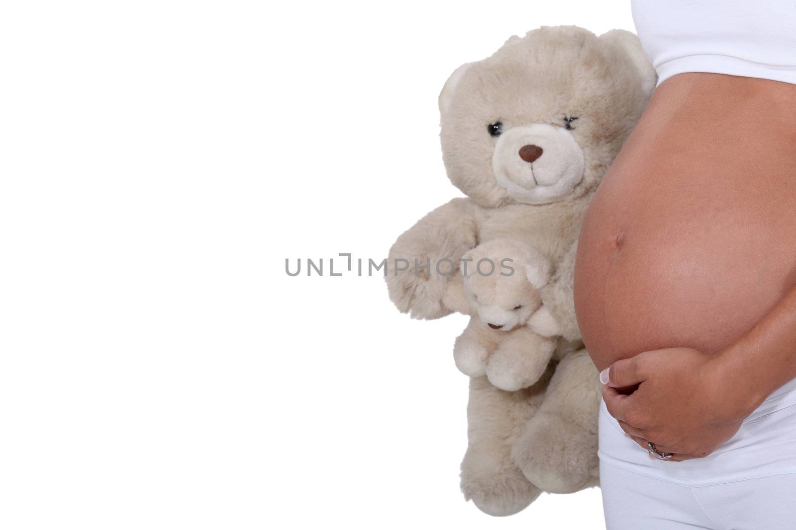 A pregnant woman holding a teddy bear.