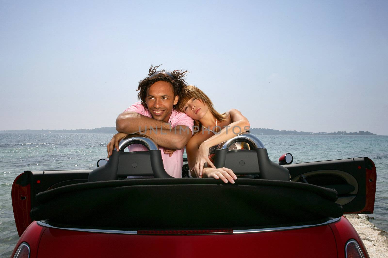 couple on a summer vacation embracing in their car