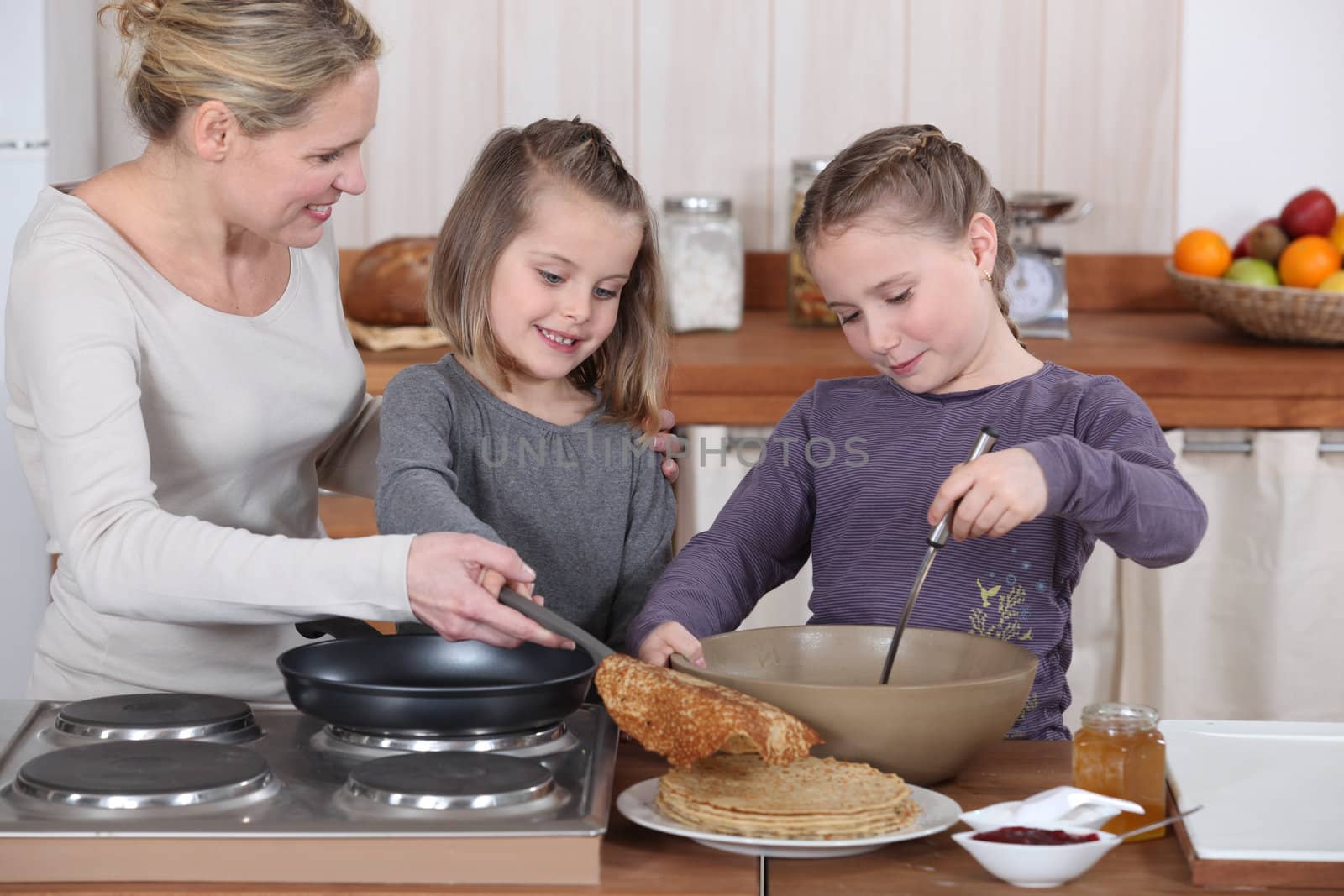 Mother and daughters making pancakes