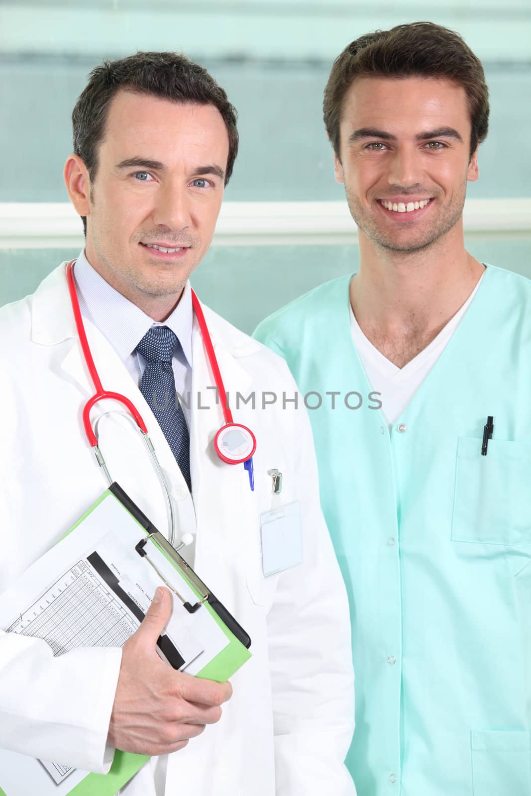 Male doctor and nurse with clipboard