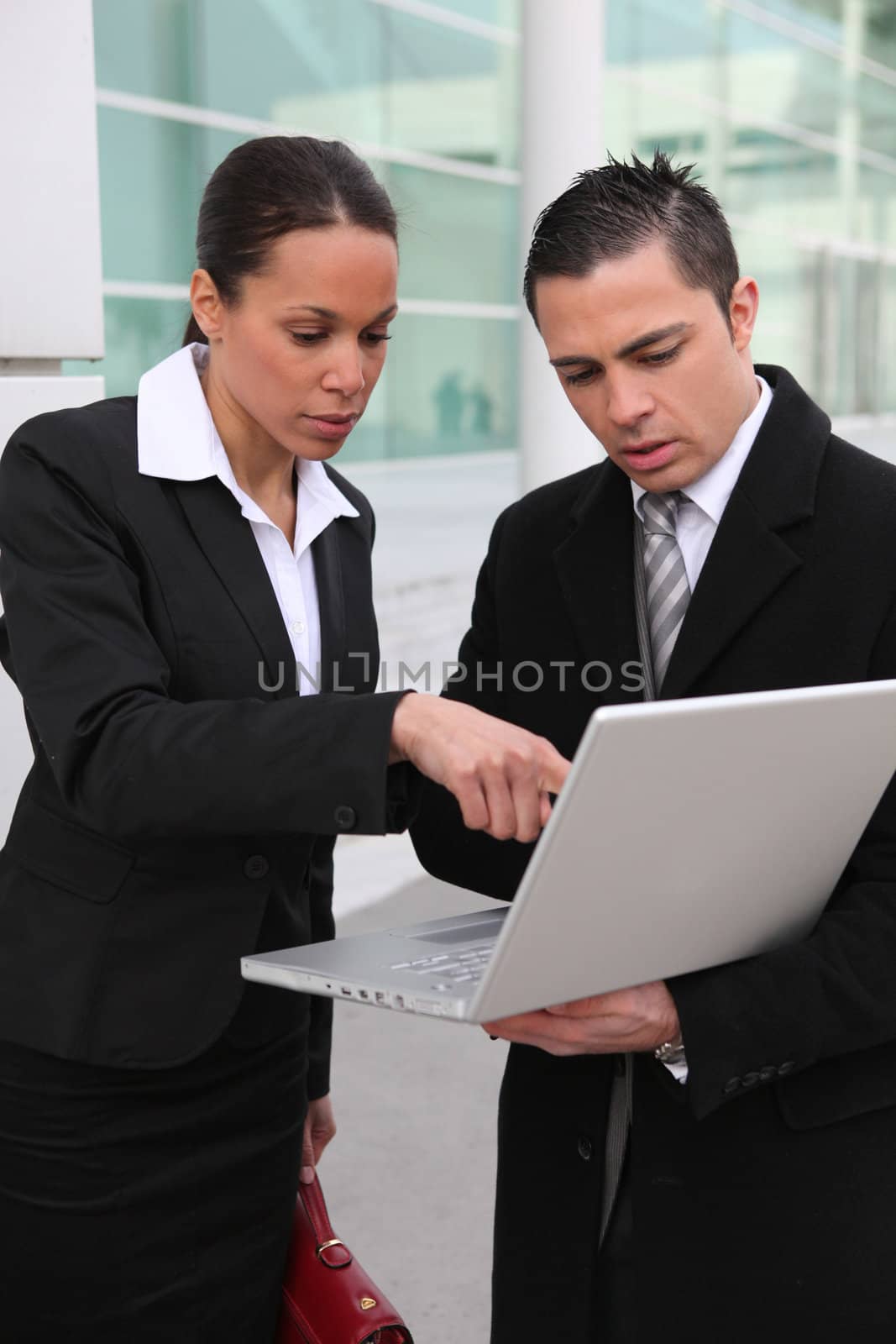 A team of business professionals looking at a laptop