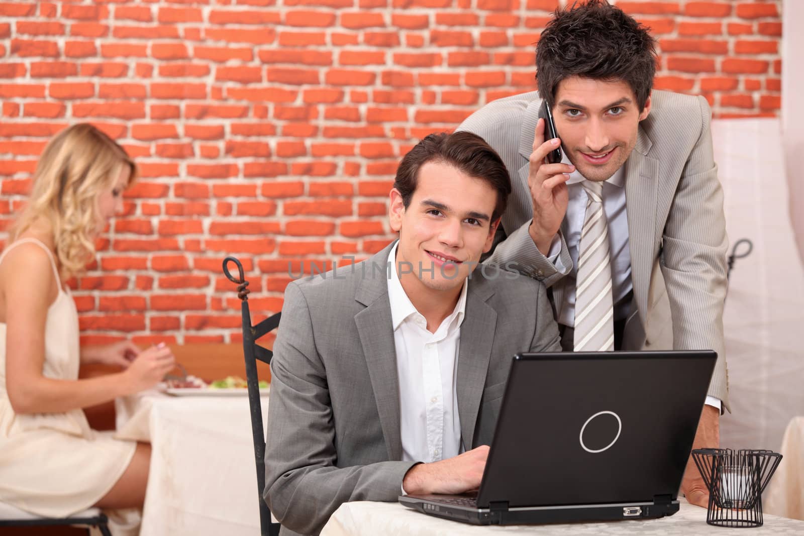 Businessmen smiling working on laptop