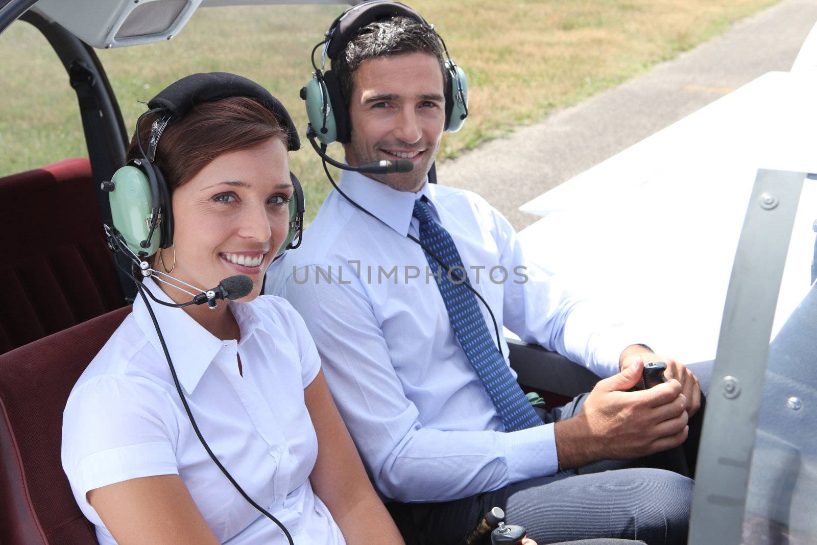 Man and woman in the cockpit of a light aircraft by phovoir