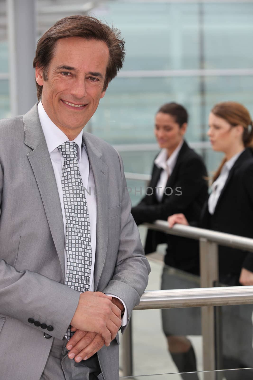 Businessman standing outside by phovoir