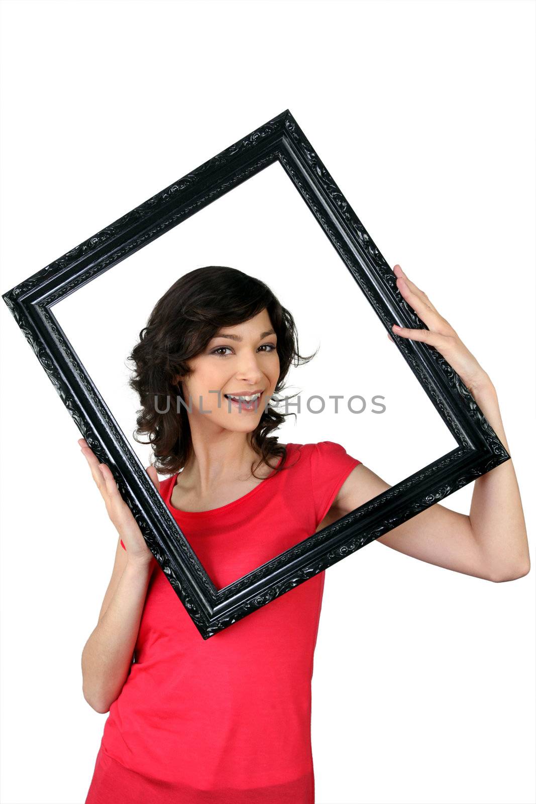 Woman holding herself within a picture frame by phovoir