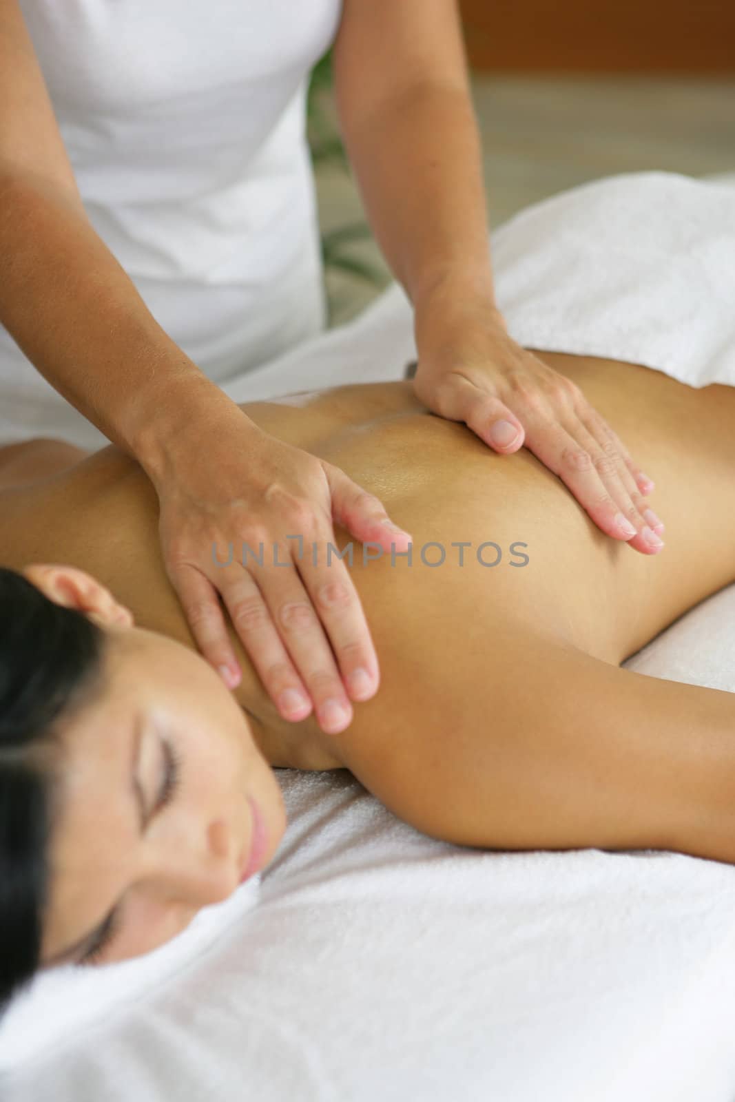 woman having a massage in a spa center by phovoir