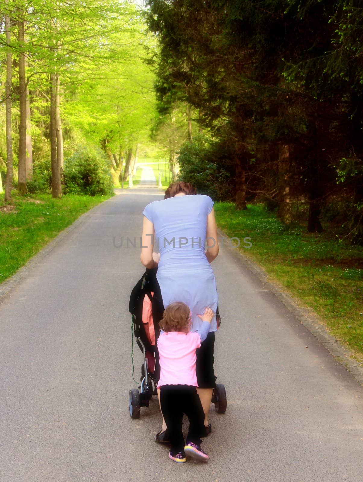 Young and happy family having fun in the park, relaxing, enjoying in beautiful early spring nature.