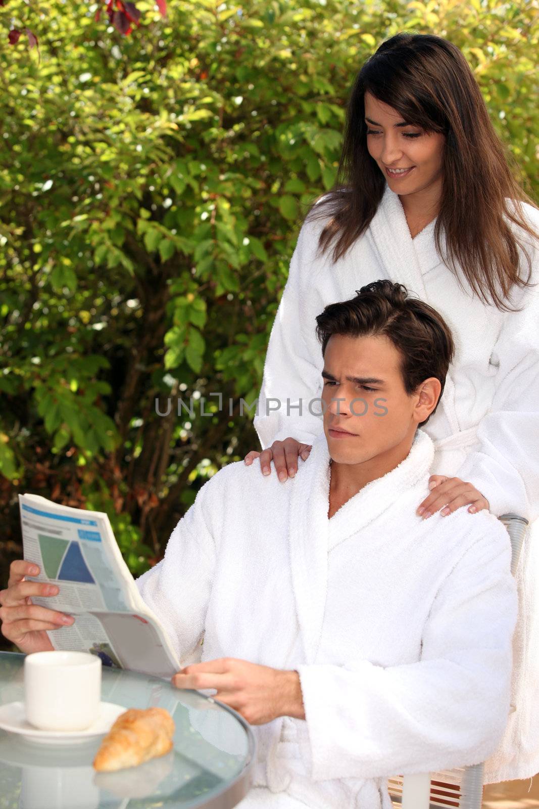 Young couple in the morning wearing bathrobe on a terrace