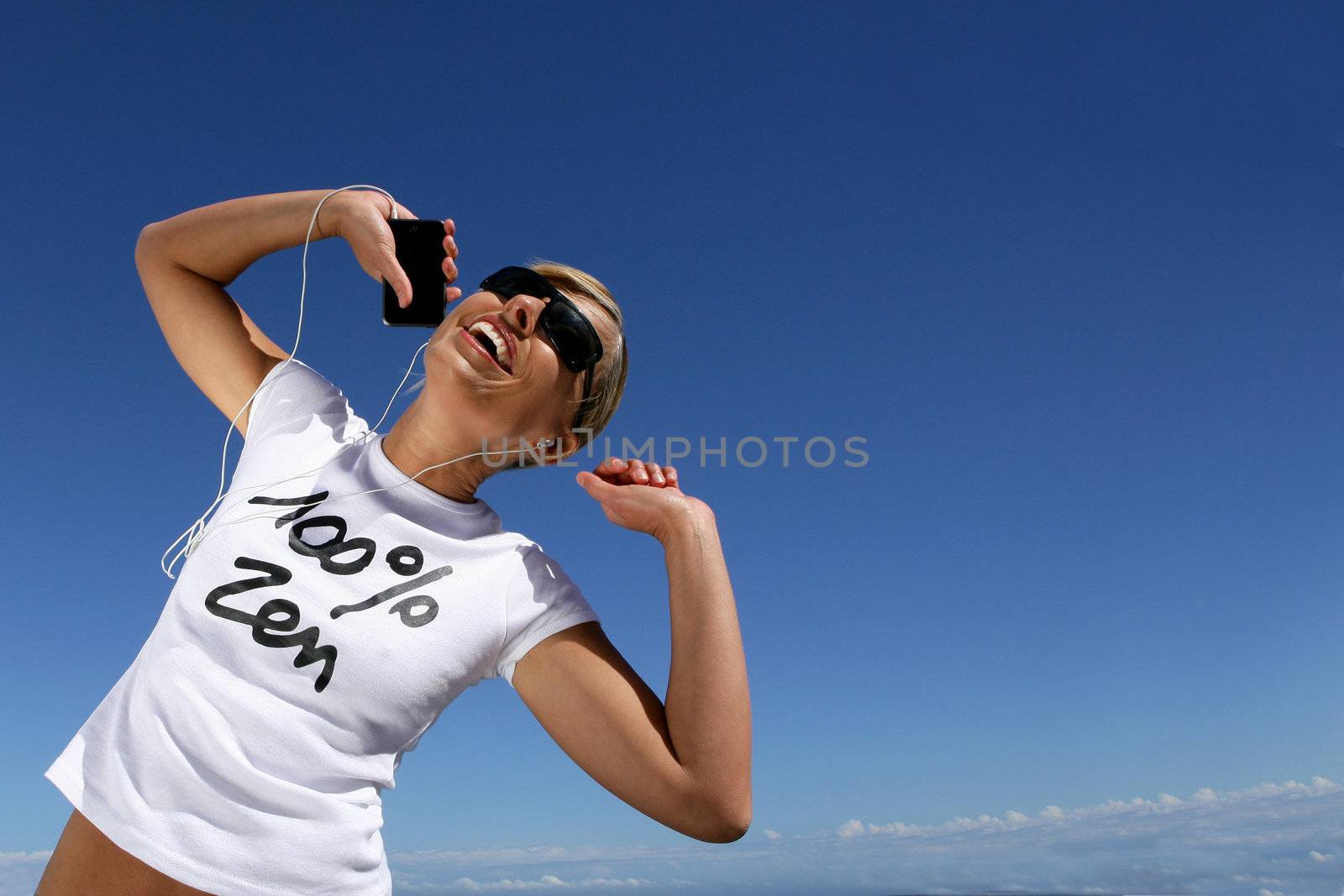 Woman dancing while listening to her mp3 player by phovoir