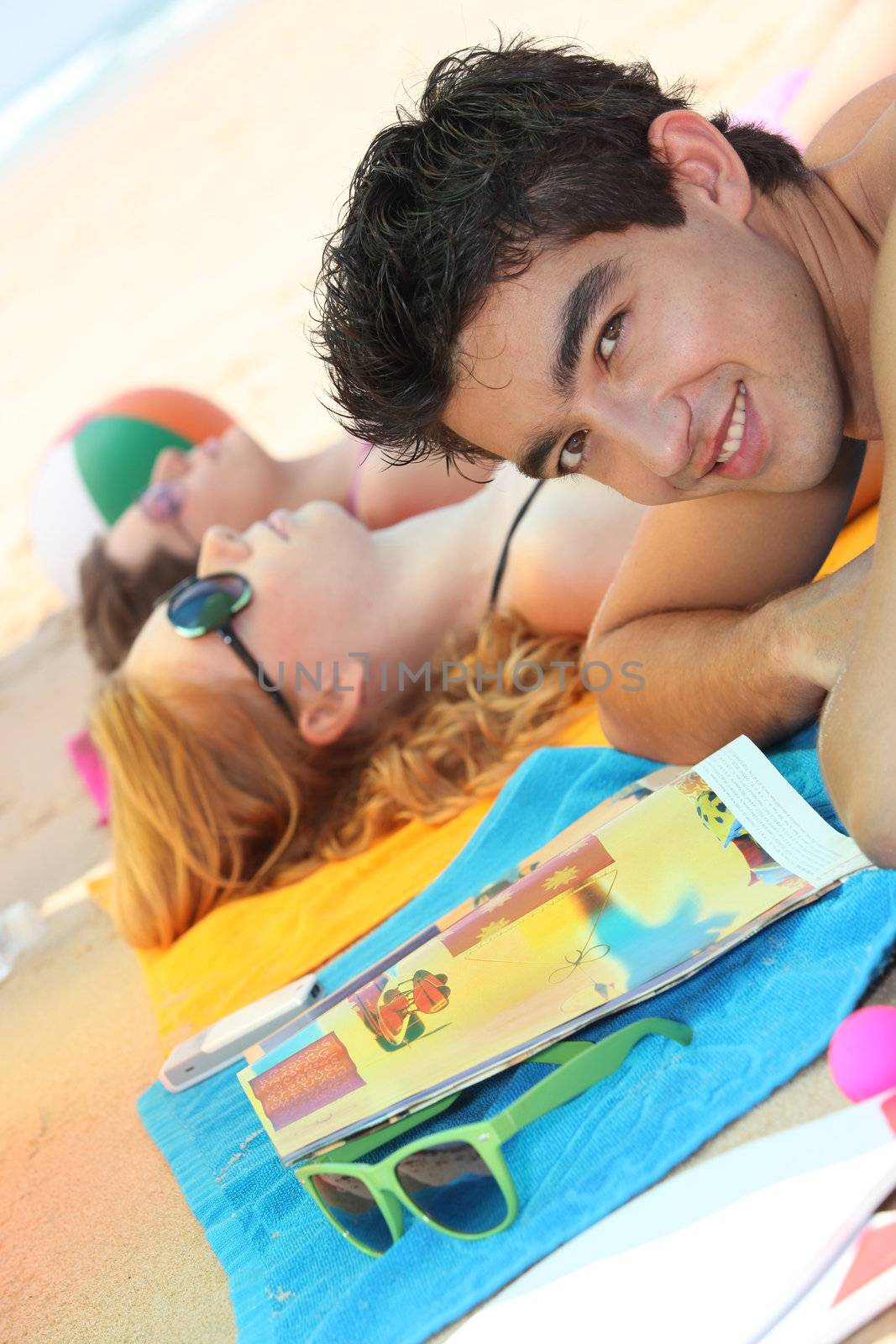 Young people on a beach by phovoir