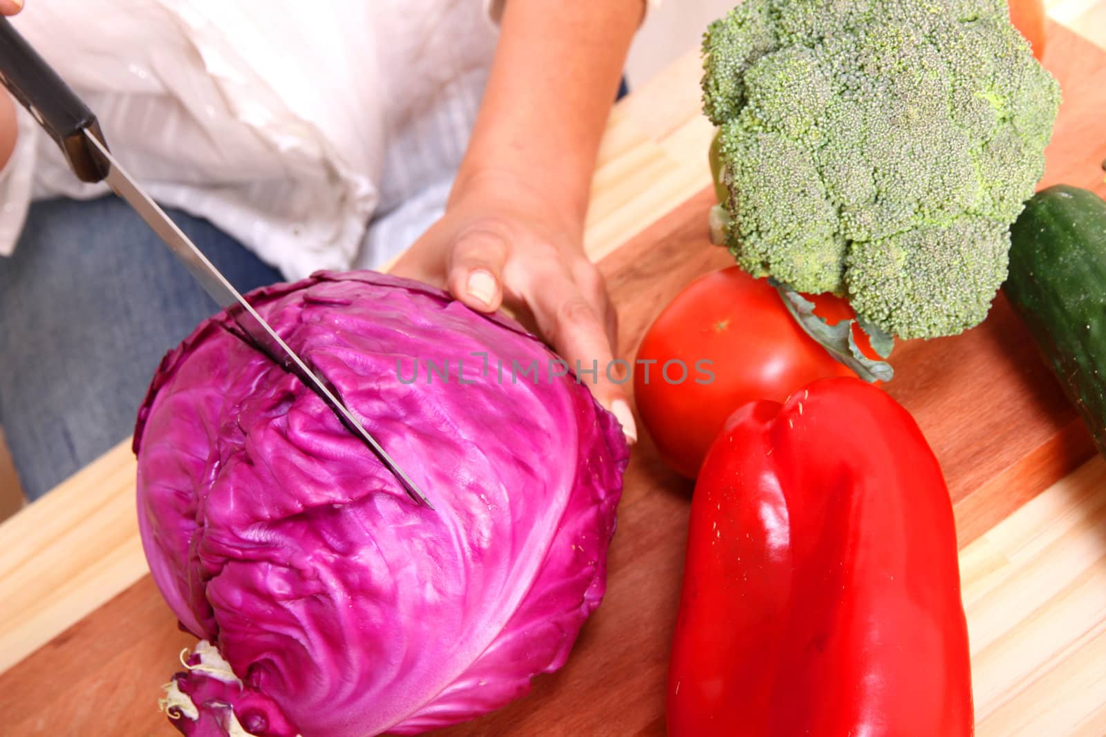 A beautiful mature woman cutting vegetables in the kitchen.