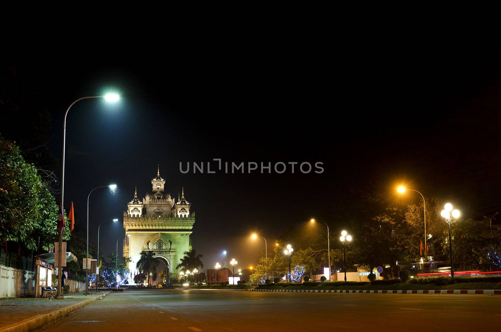 patuxai arch at night in vientiane, laos by jackmalipan