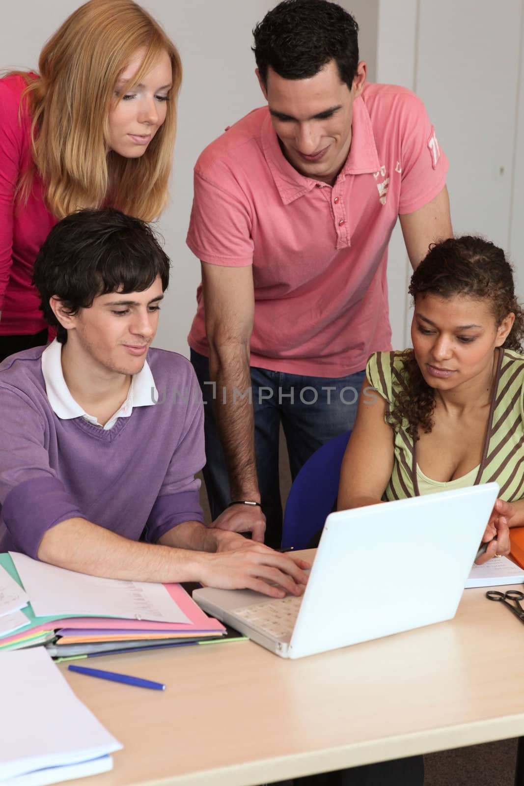 Four students in front of laptop