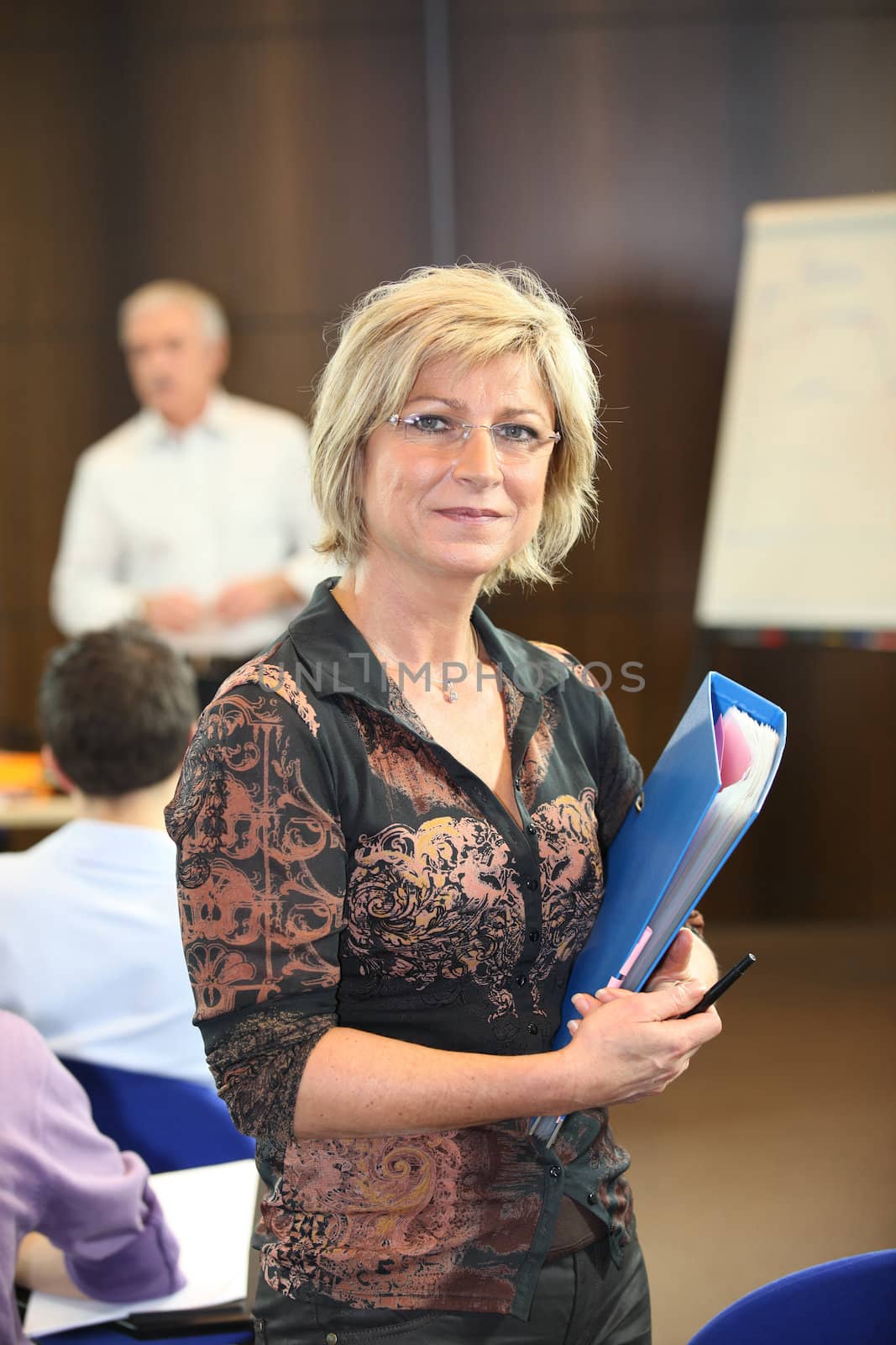 Woman holding a file during a presentation by phovoir