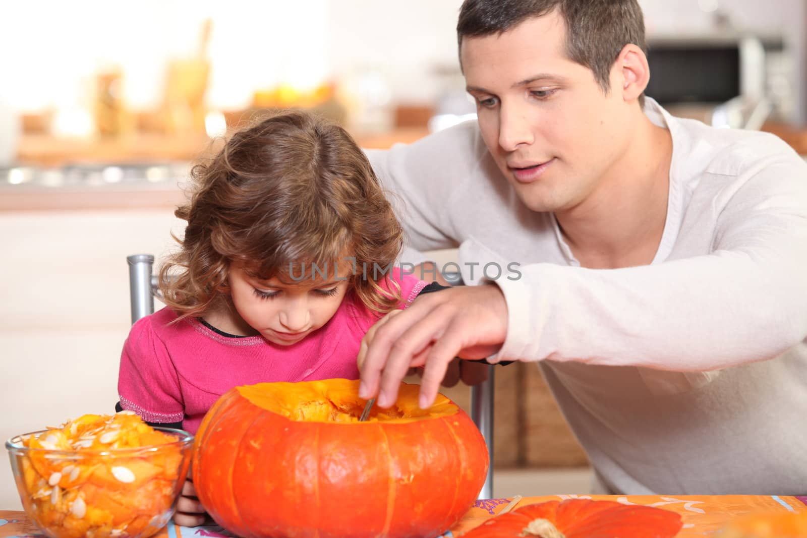 Father and daughter preparing pumpkin by phovoir