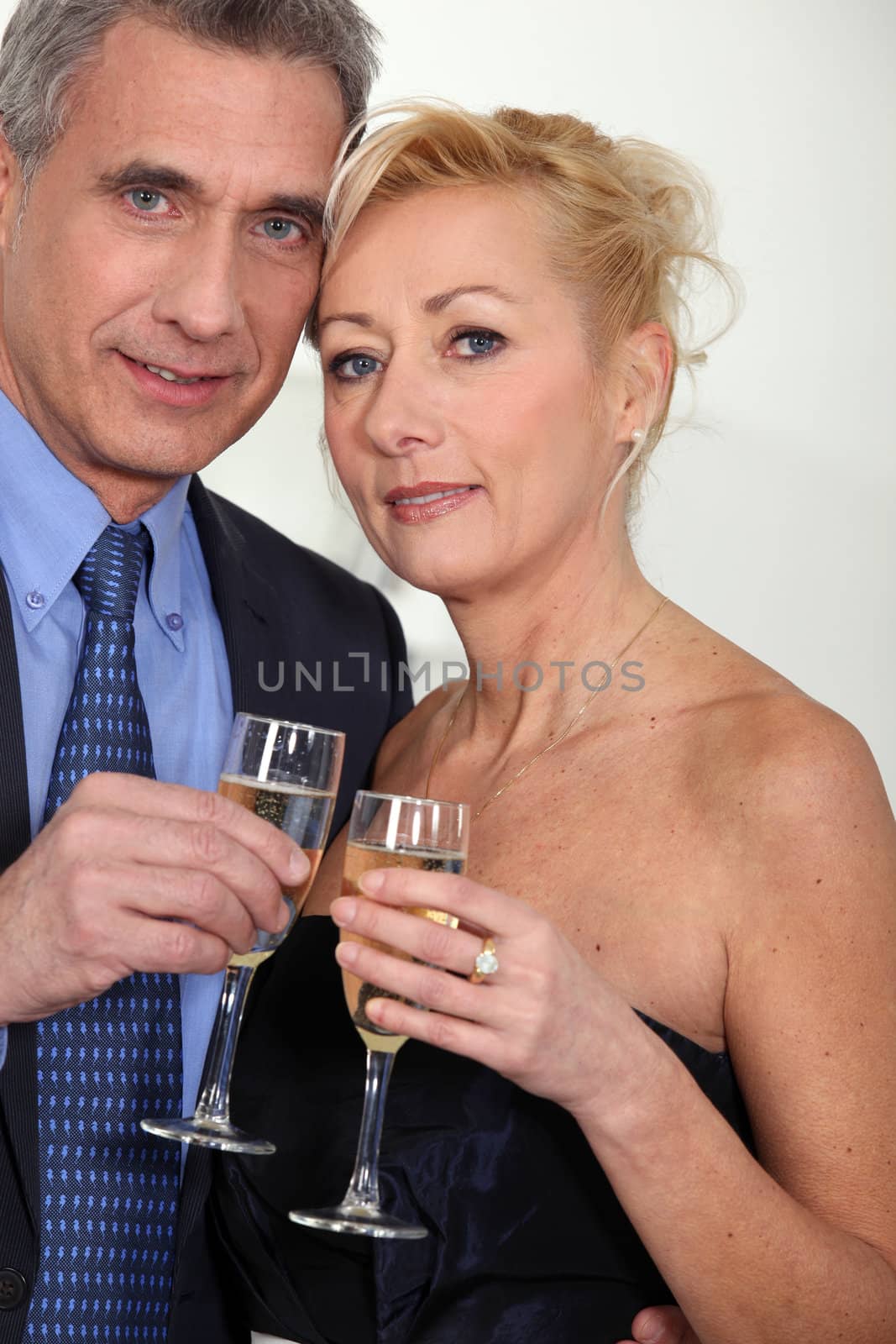 Mature couple toasting with champagne.