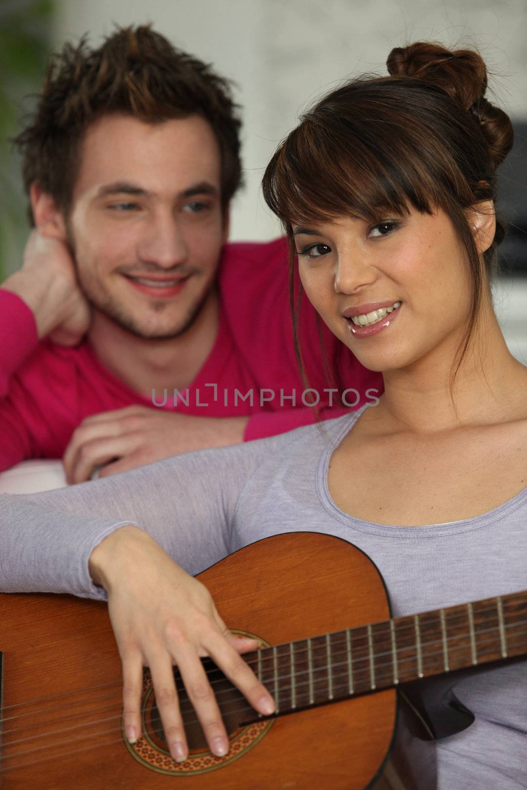 Girlfriend playing the guitar for her boyfriend