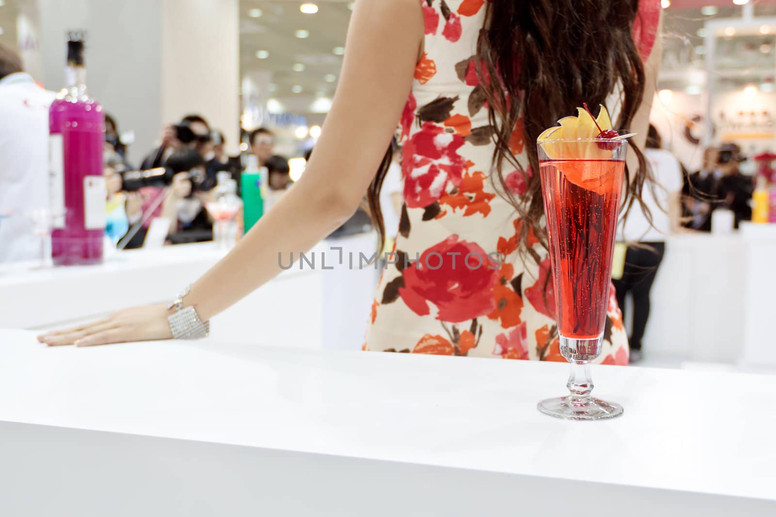 A tall glass of cocktail "Eliza" with a girl on background