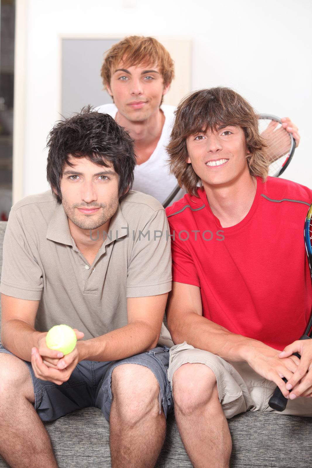 Three lads about to have a casual game of tennis