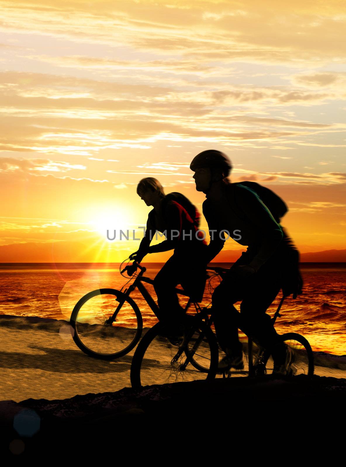 Couple on bicycles on the brink of a rock near sea