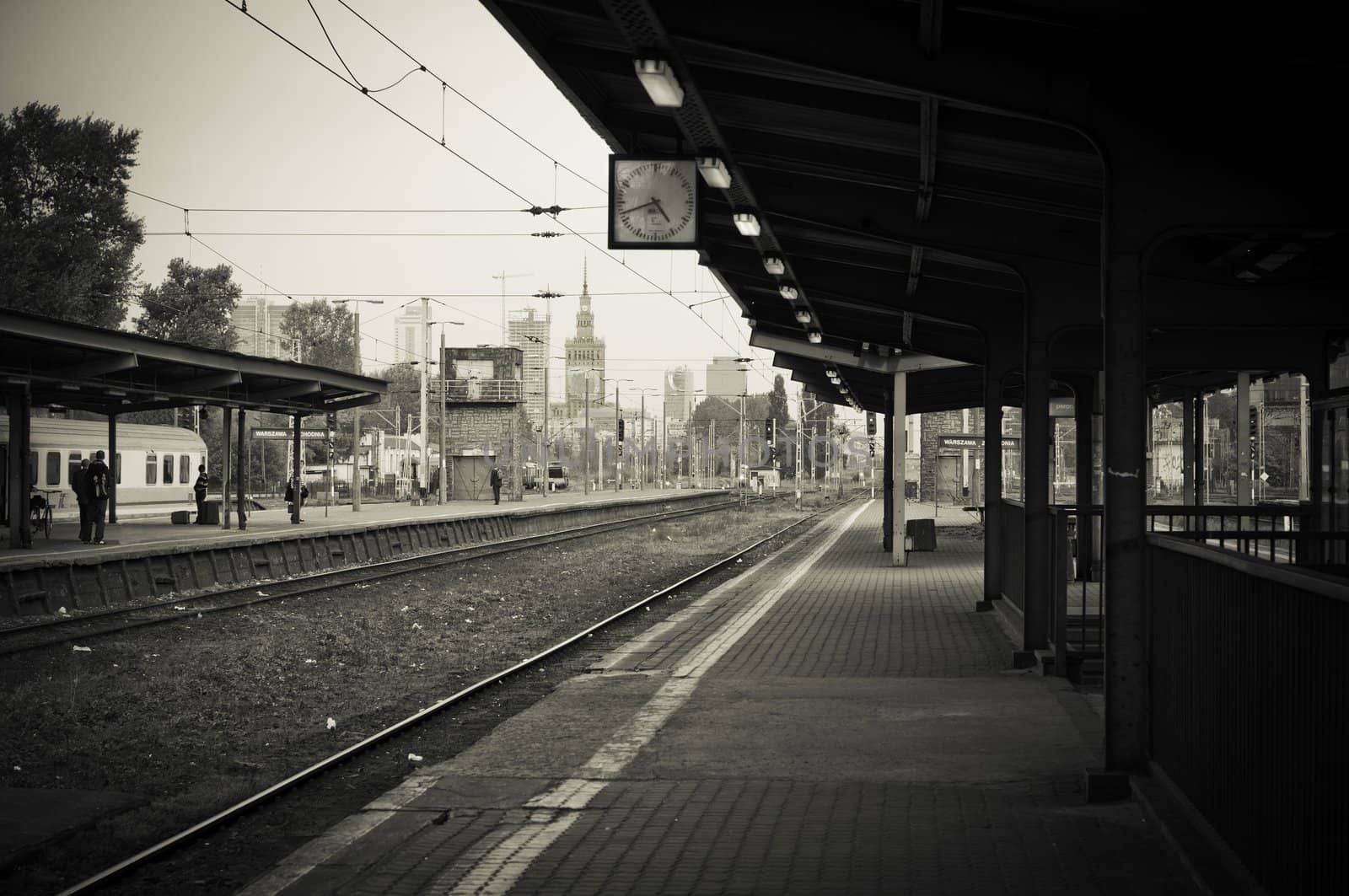 black and white photo of railway station in Poland "Warszawa Zachodnia" - palace of science and culture in the background