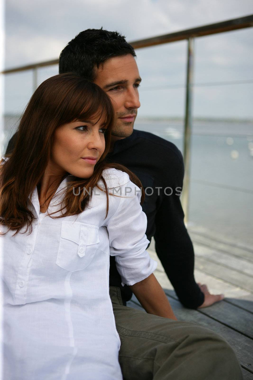 Couple on a terrace looking away by phovoir