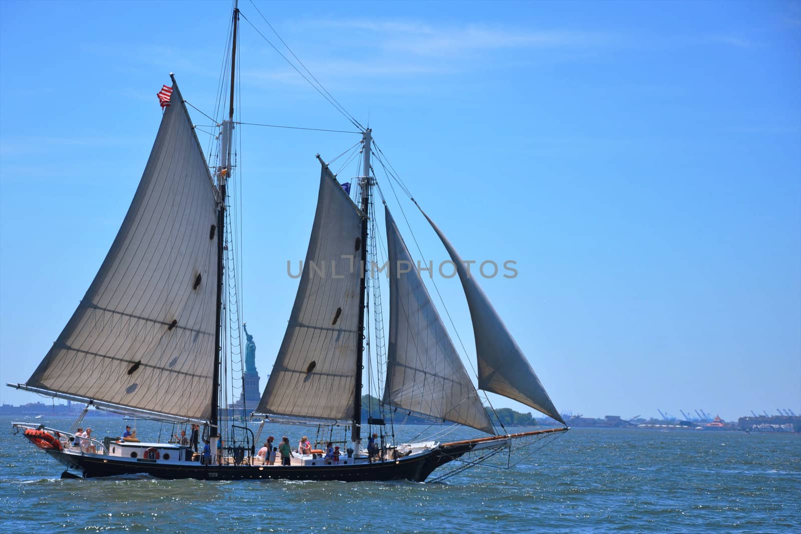 The statue of Liberty is seen through the masts of a tall ship in New York Harbour.