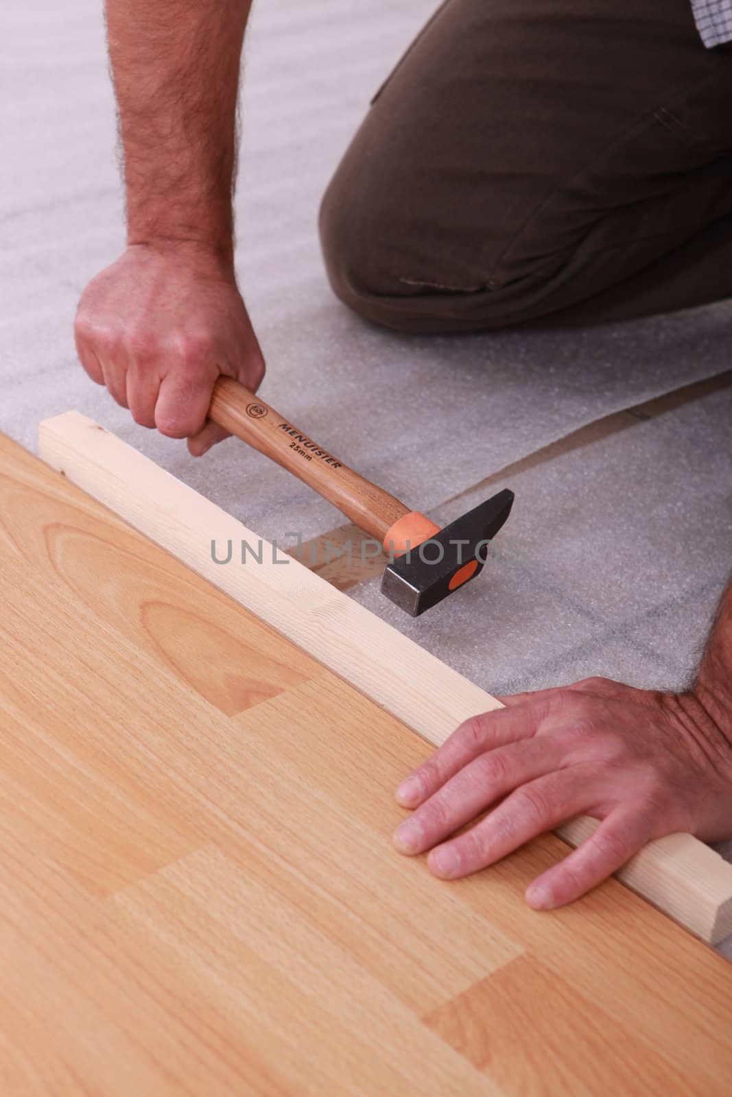 handyman laying floorboards by phovoir