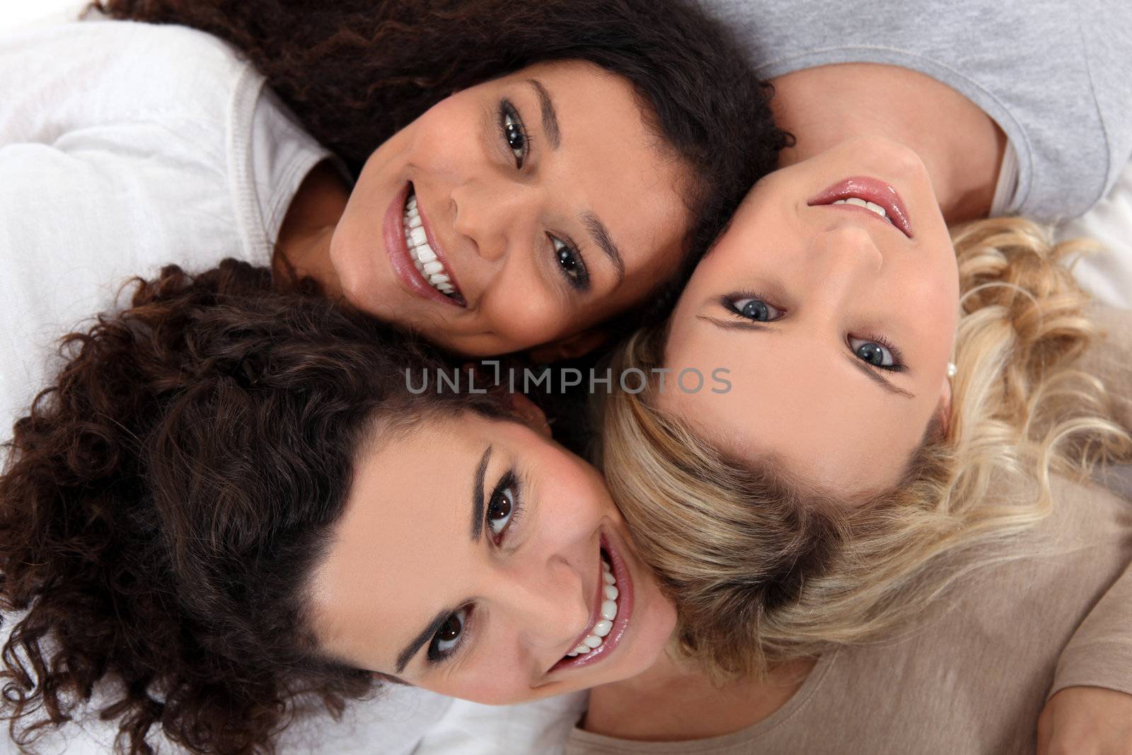 Three female friends laying down together