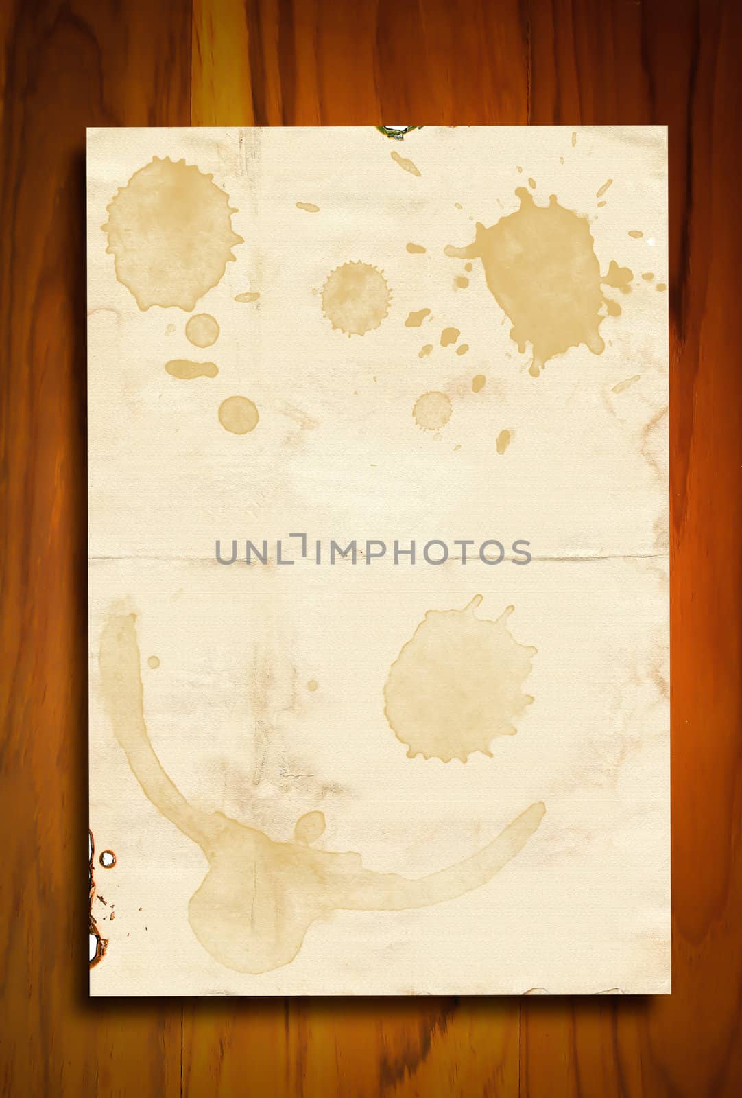 Vintage paper with coffee stains on wooden background