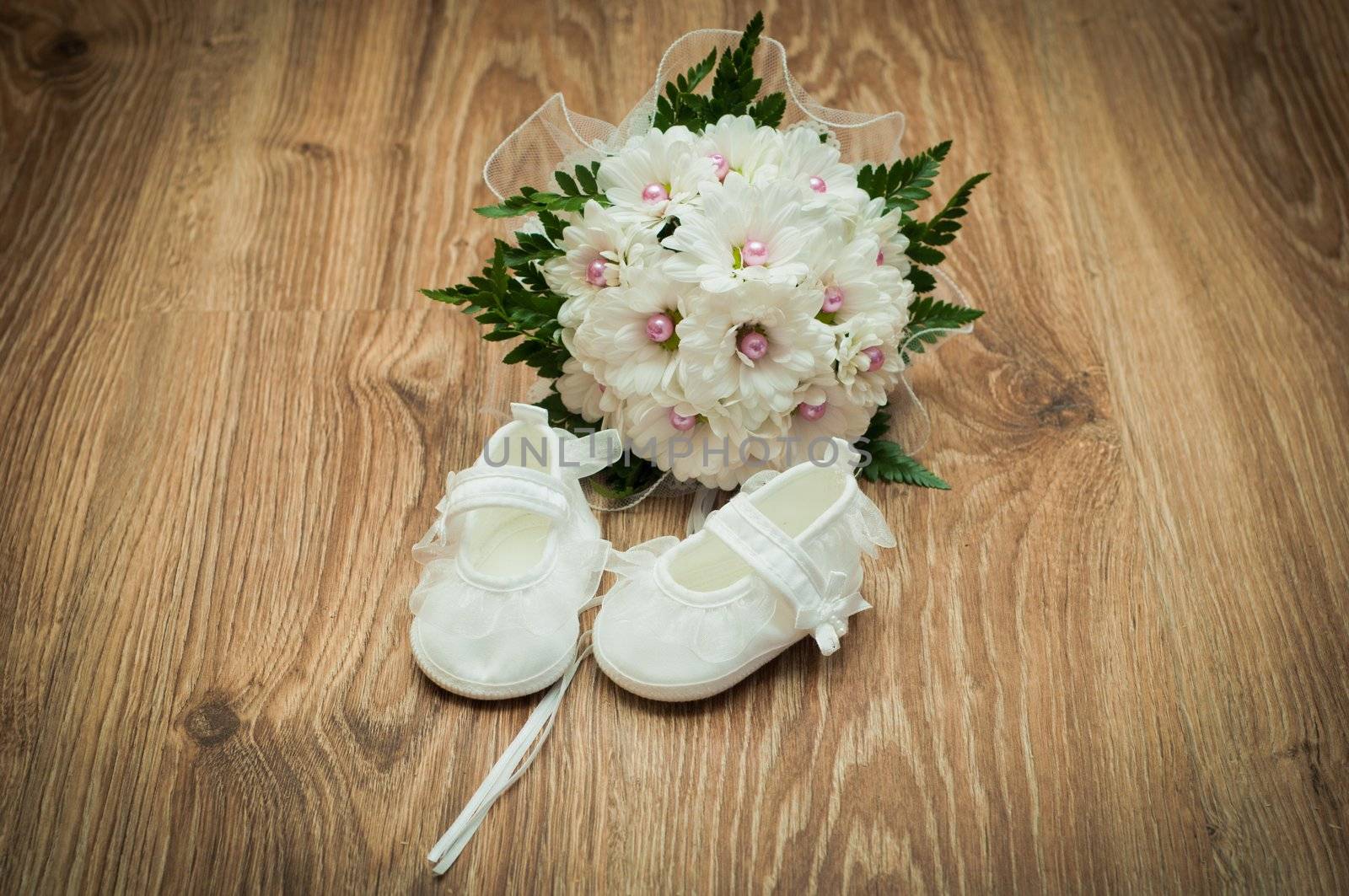 white shoes and white bouquet on a wooden floor