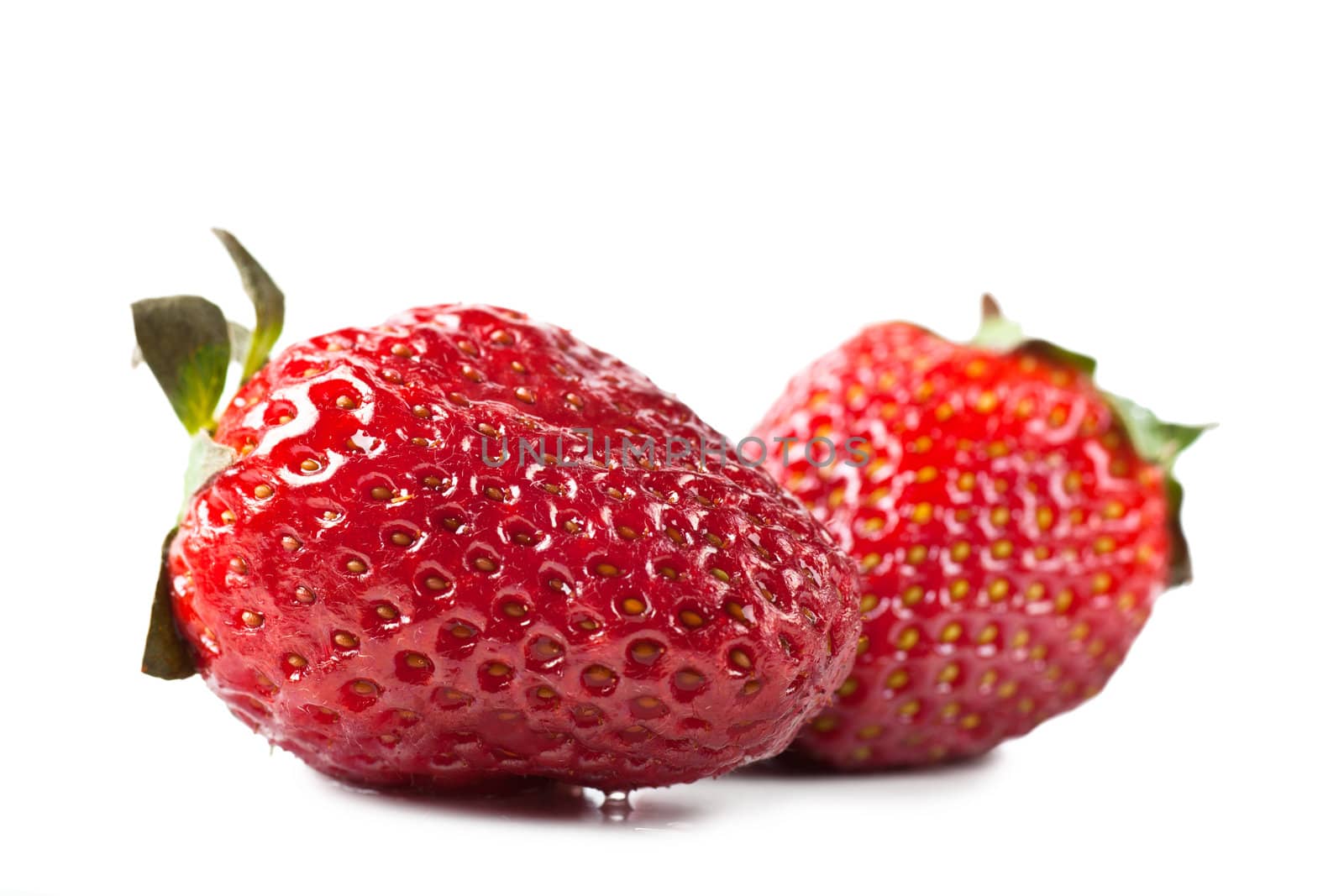 Macro view of two fresh strawberries over white background