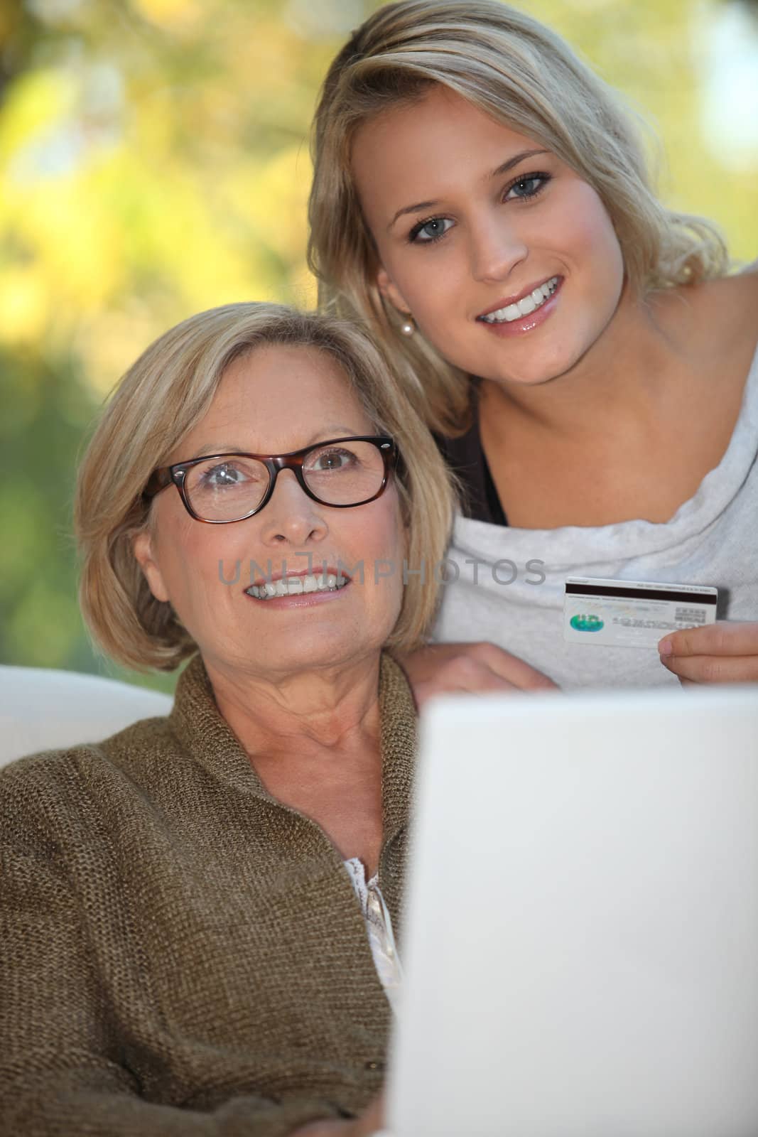 Young woman and senior woman doing shopping on Internet by phovoir