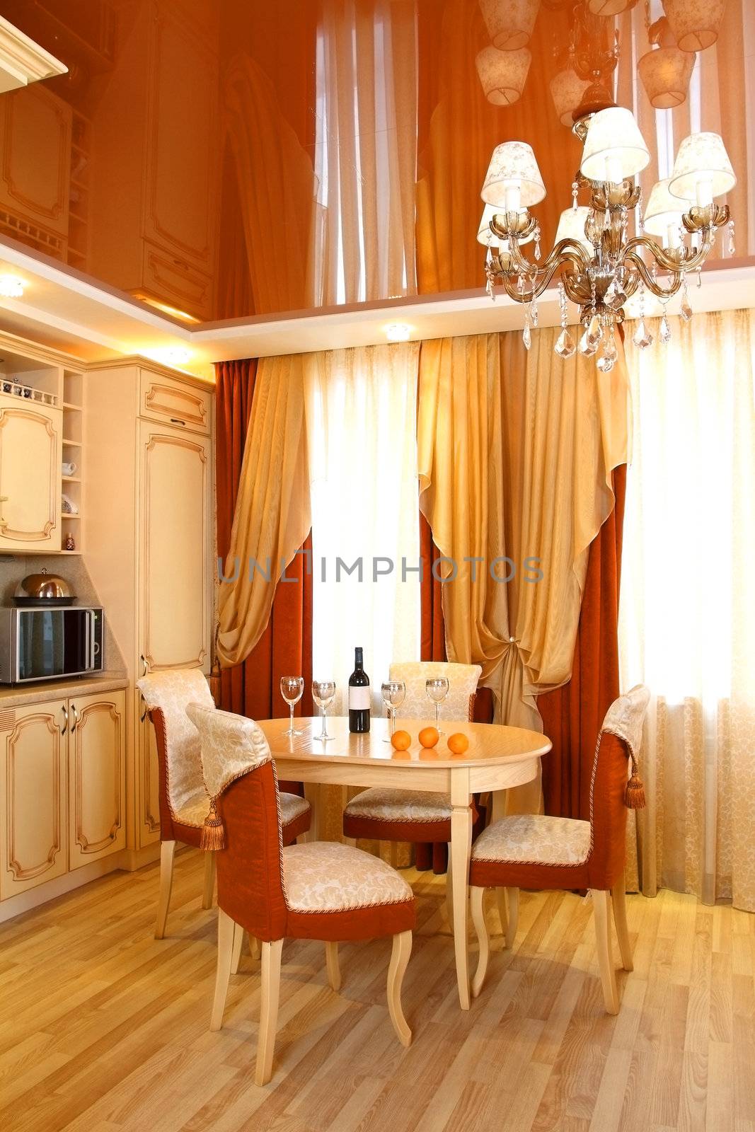 beautiful interior of kitchen with a table, a bottle of wine and glasses, a floor-to-ceiling window with a curtain, a vertical shot