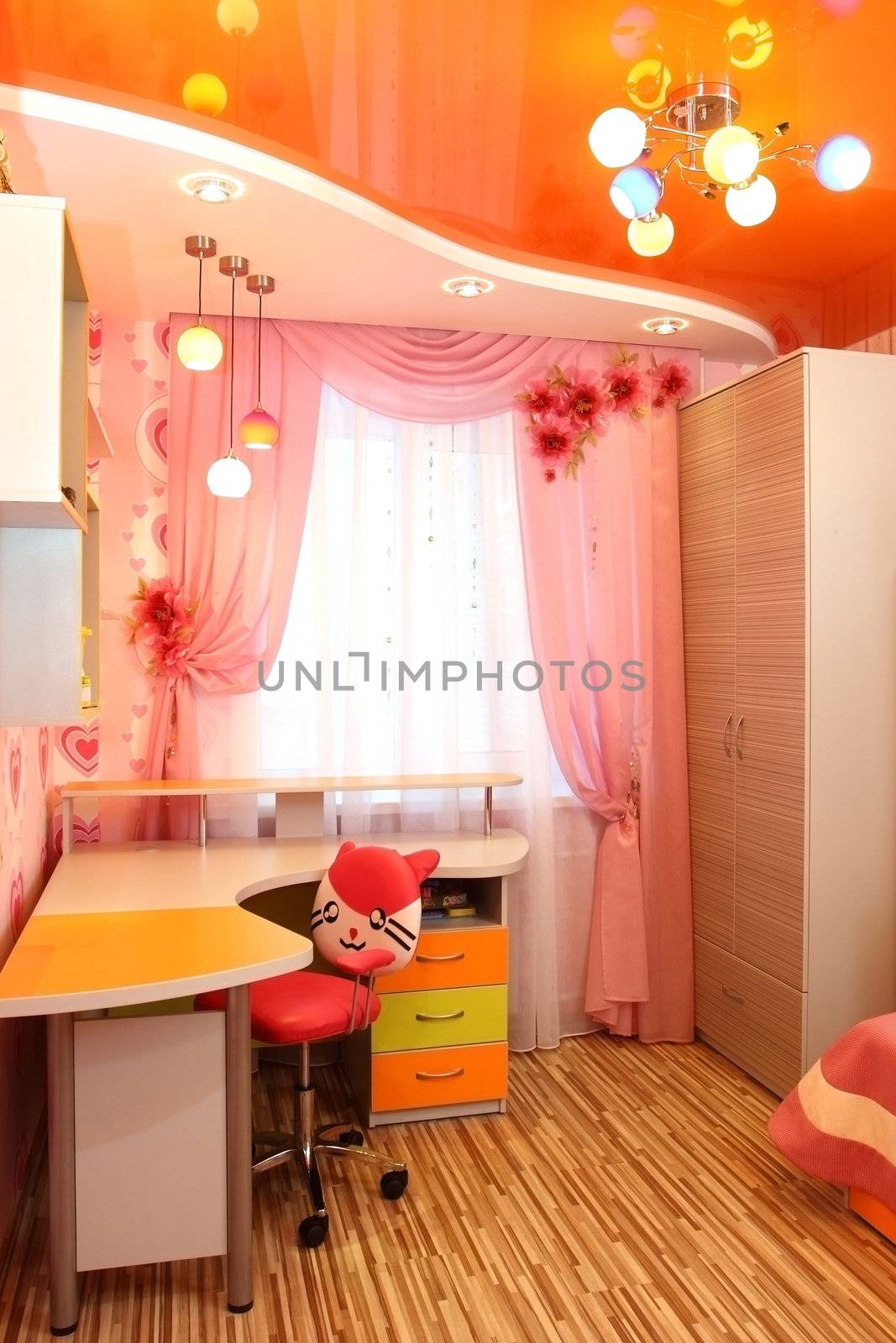 beautiful interior of a nursery with a sofa with pillows, a desk, a window with a curtain, a vertical shot