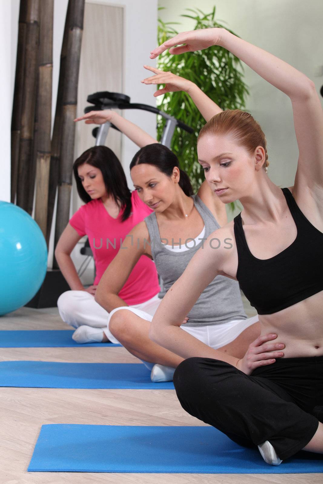 female threesome doing exercise indoors