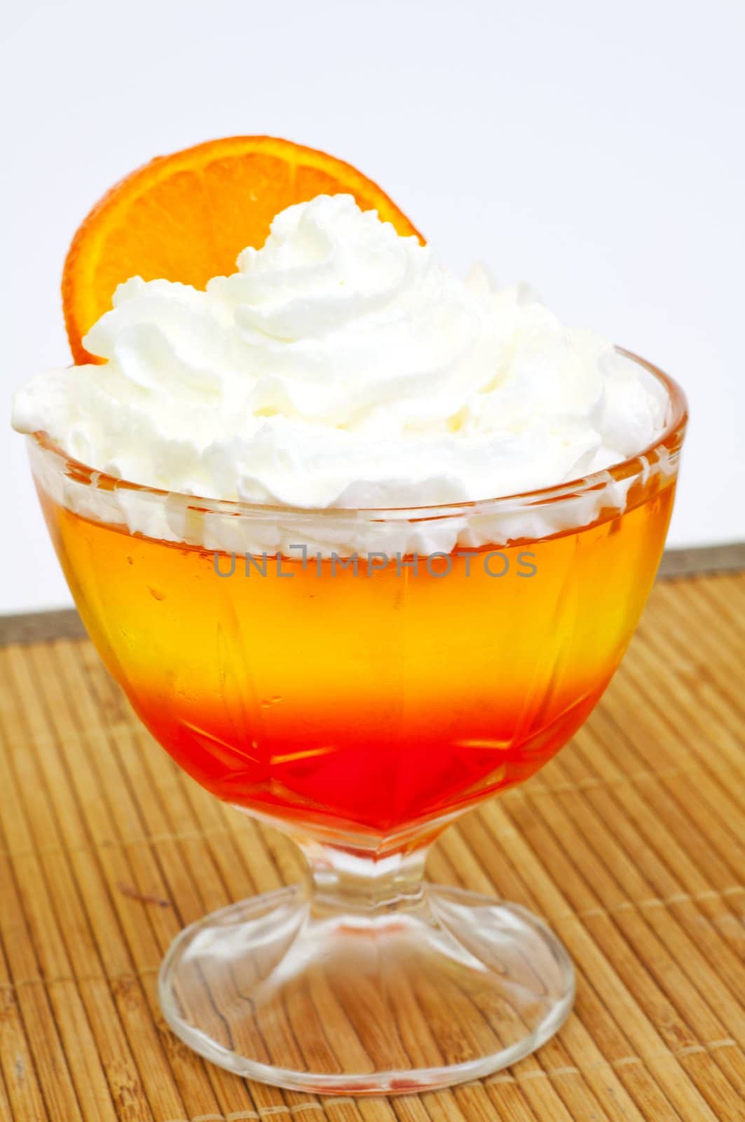 tricolor jelly with whipped cream in a glass 
