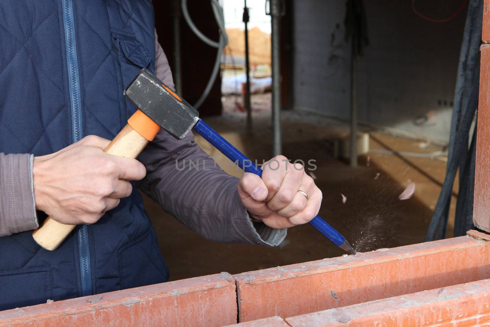 Man using hammer and chisel on wall