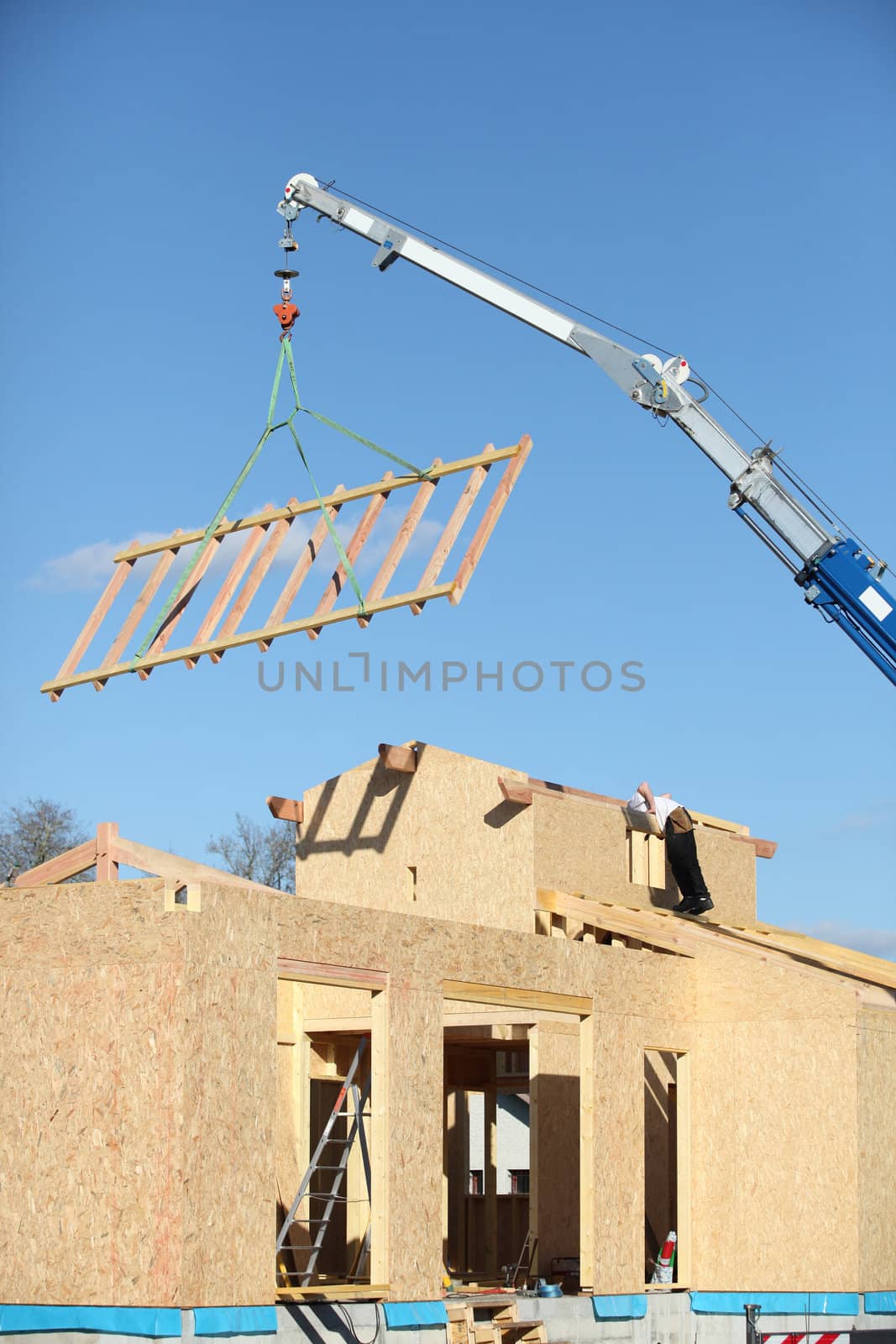 Crane lifting a wooden structure