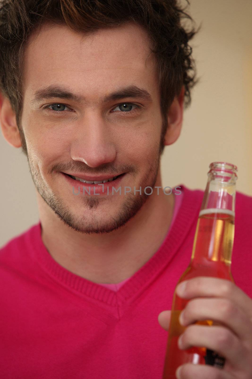 Smiling man with bottle of beer by phovoir