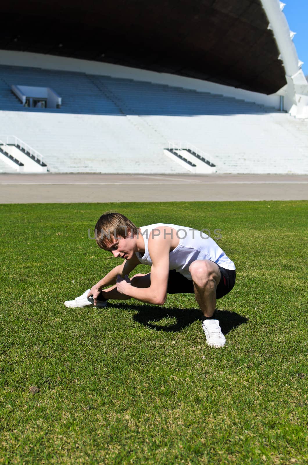 Runner at the city stadium warming and stretching