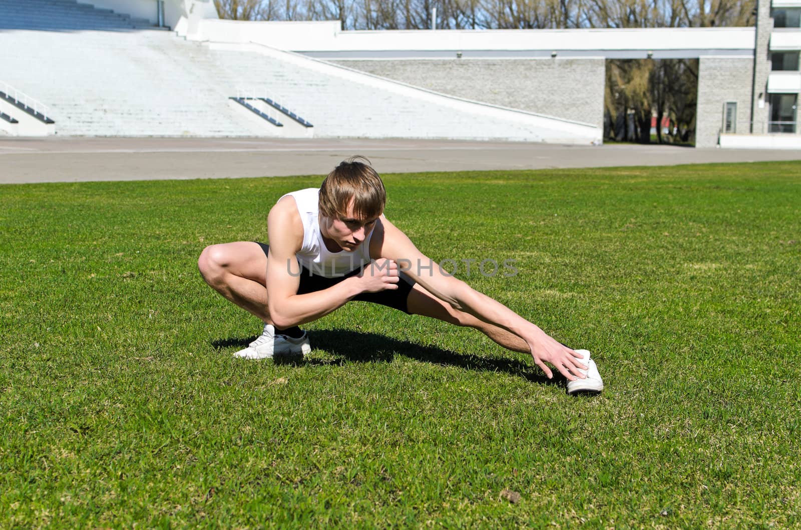 Runner at the city stadium warming and stretching