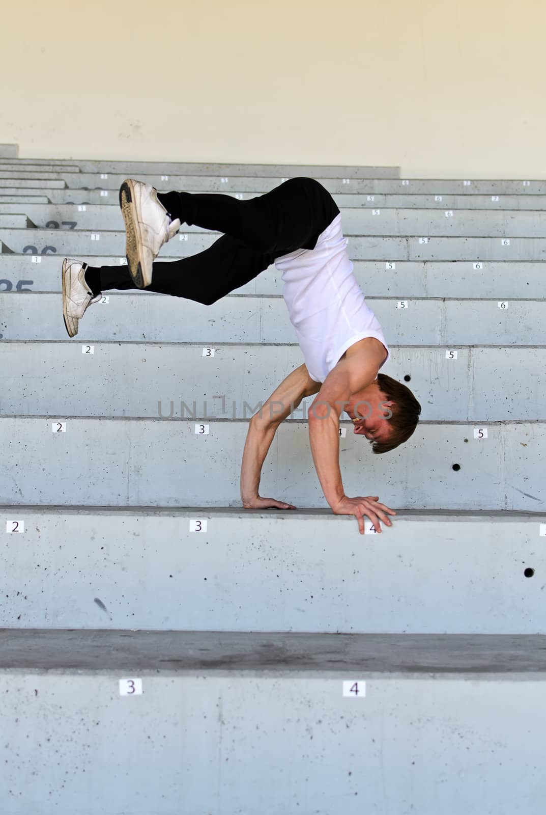 Portrait of athletic male doing flip on empty stadium