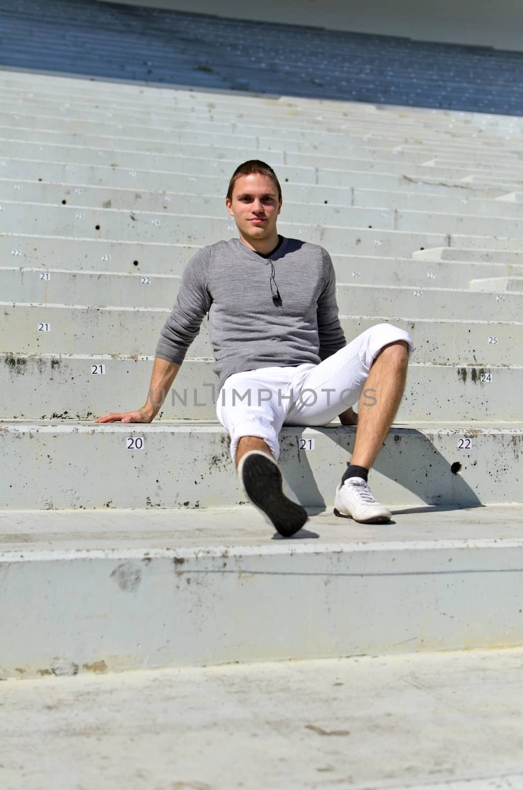Young athletic guy in an empty stadium