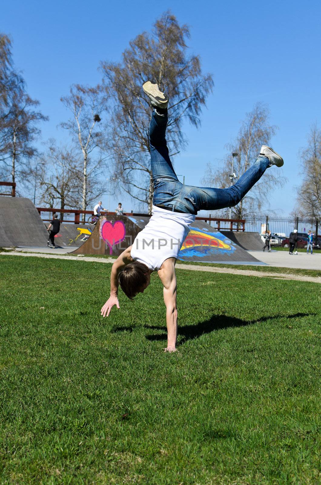 Breakdancer doing a flip on the grass.