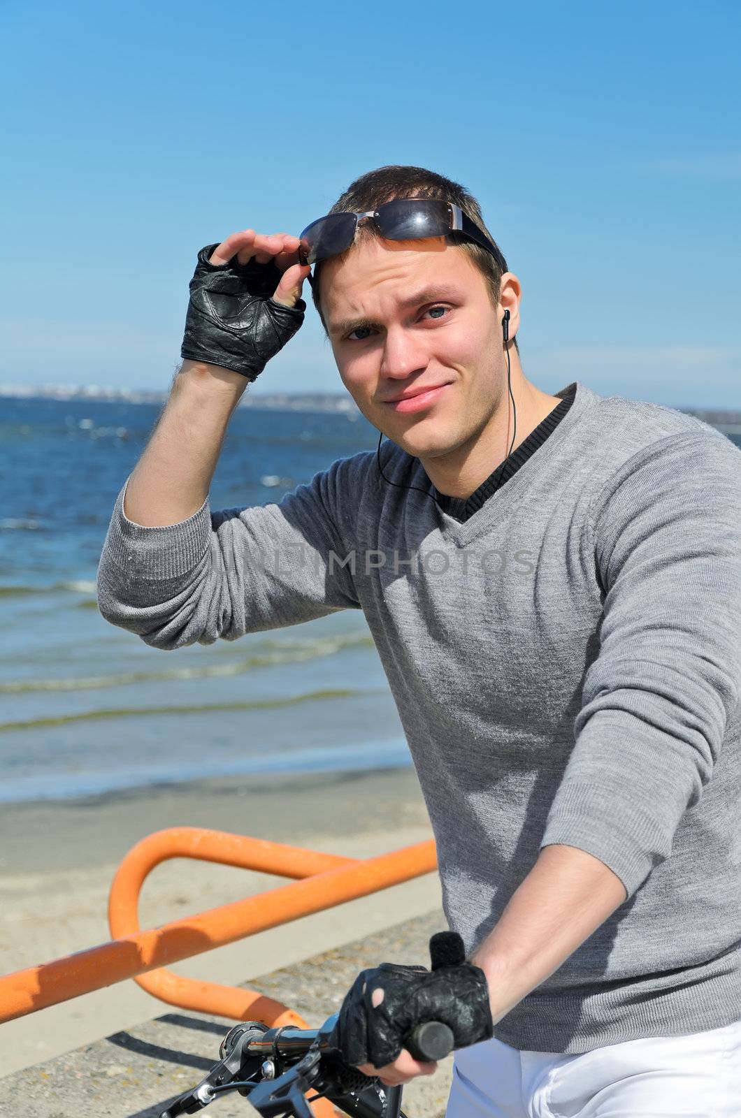 Portrait of handsome male with bicycle by the sea